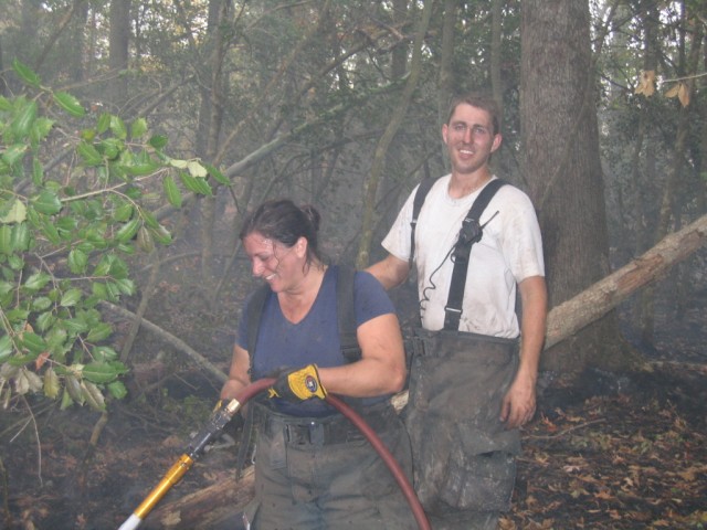 Firefighter/EMT Cenate working while Firefighter/EMT Miller cheeses for the camera